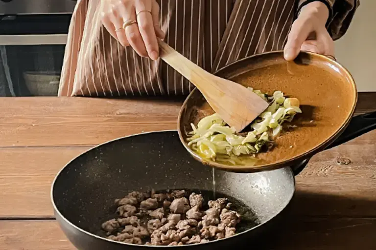 Chefs adds fennel mixture to the pan.