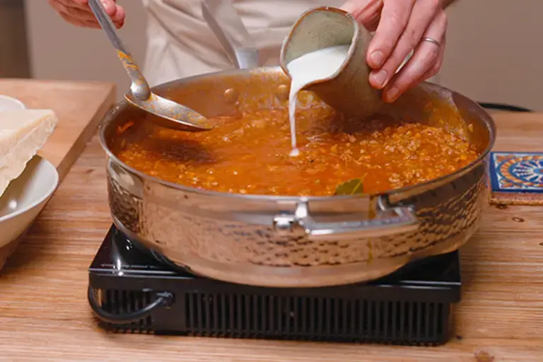 Adding milk to the ragù.