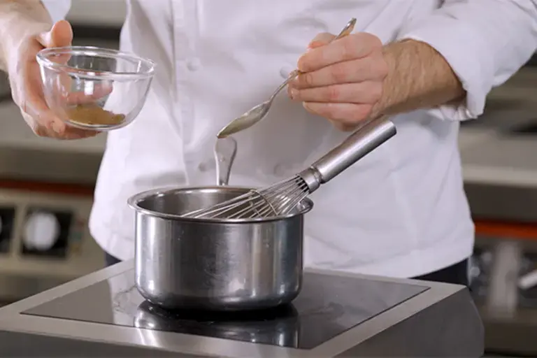 Nutmeg being added to a pan.