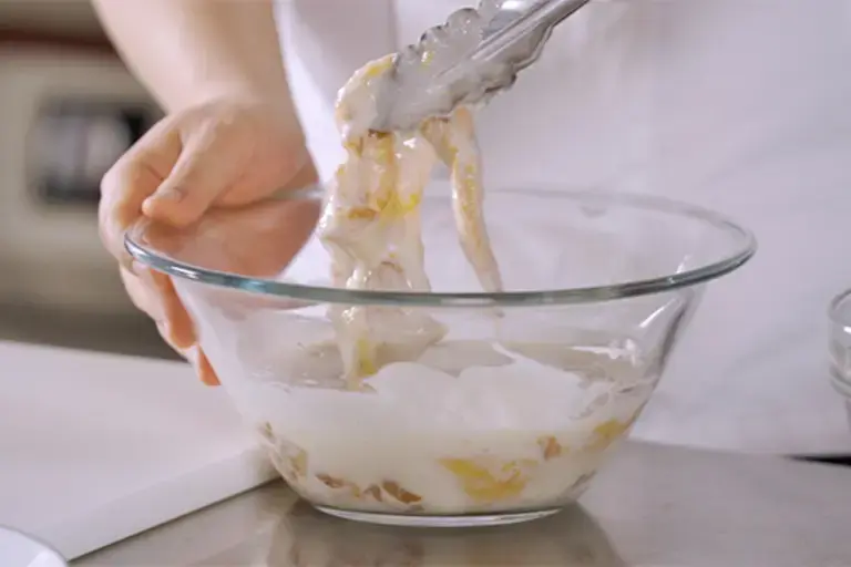 A piece of meat being coated in a paste.