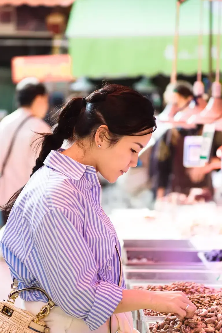 Chef Vicky Lau sniffing fruit in a wet market in Yunnan.