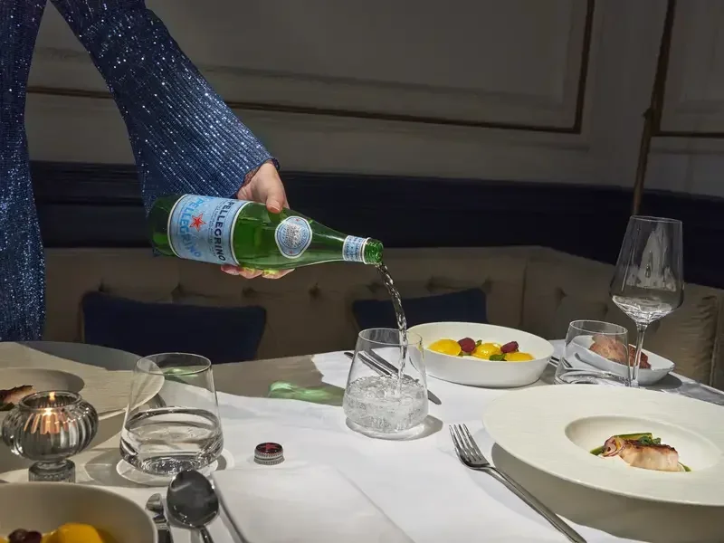 S.Pellegrino being poured at a dining table.