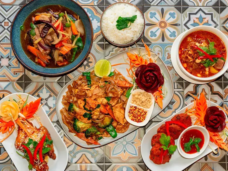 A spread of Thai food on a patterned surface.
