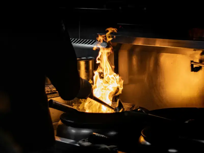 Cooking with flame using a wok
