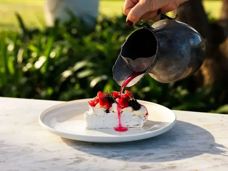 Pouring sauce over pavolva at Sara Dining.