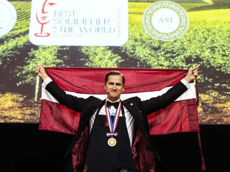 Raimonds Tomsons holding the Latvian flag.
