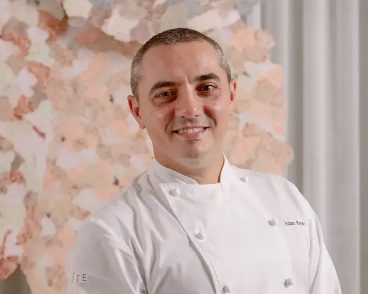 Chef Julien Royer in a chef's jacket, smiling.