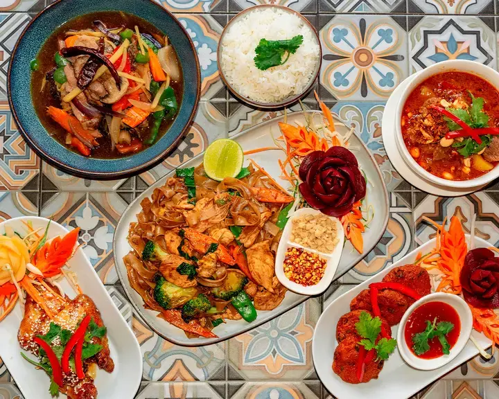 A spread of Thai food on a patterned surface.