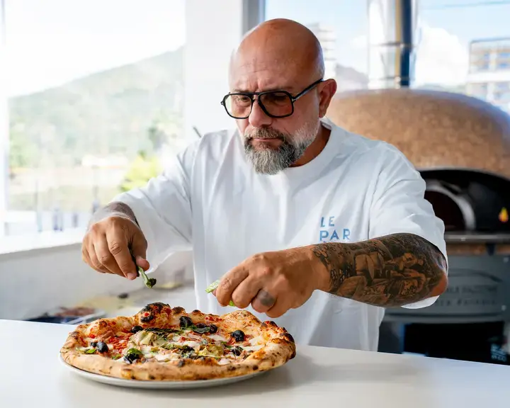 Chef Giuseppe Pignalosa placing toppings on a capricciosa.