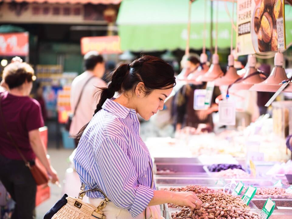 Chef Vicky Lau sniffing fruit in a wet market in Yunnan.
