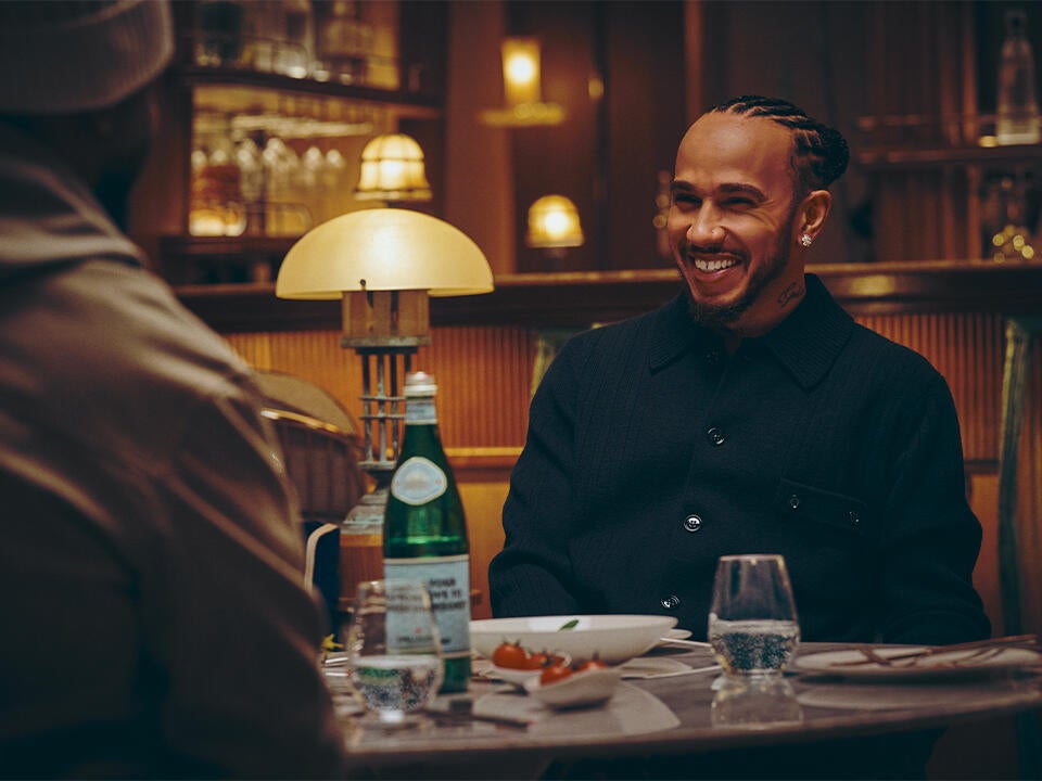 Lewis Hamilton at a restaurant table with S.Pellegrino.